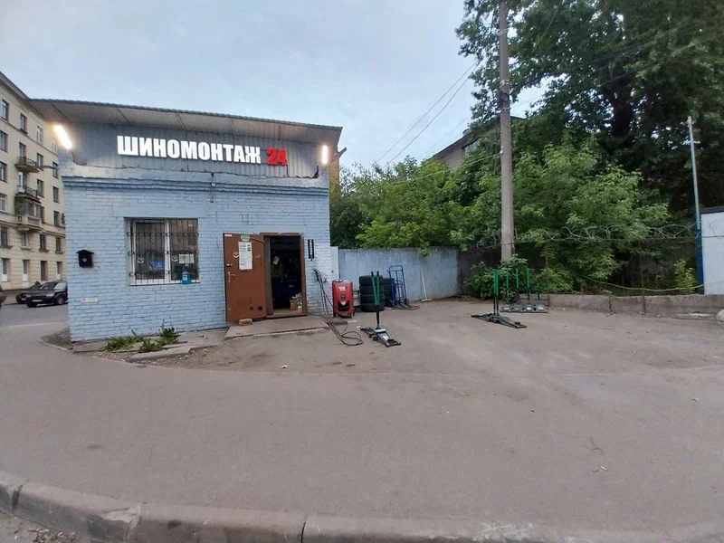 Специалист шиномонтажа работает с автомобилем
